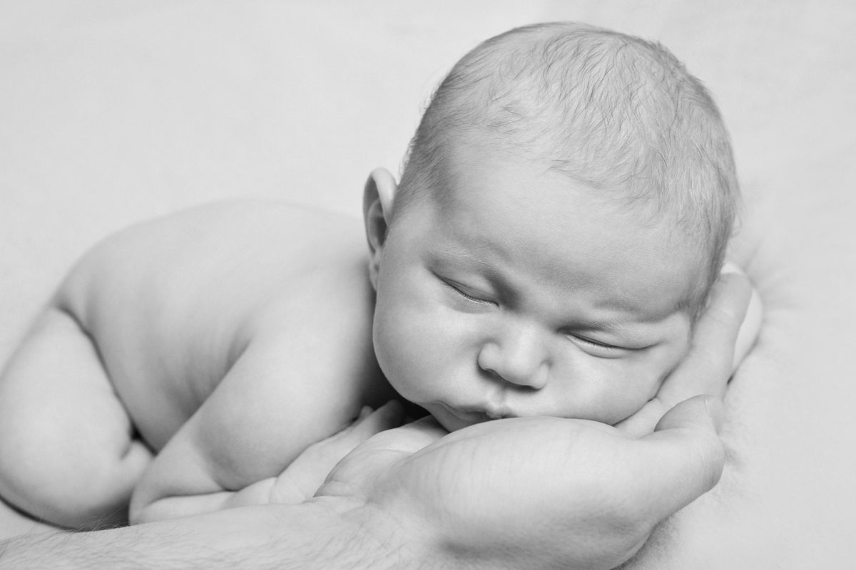 portrait of newborn baby lying on the hands of parents. the concept of newborn health